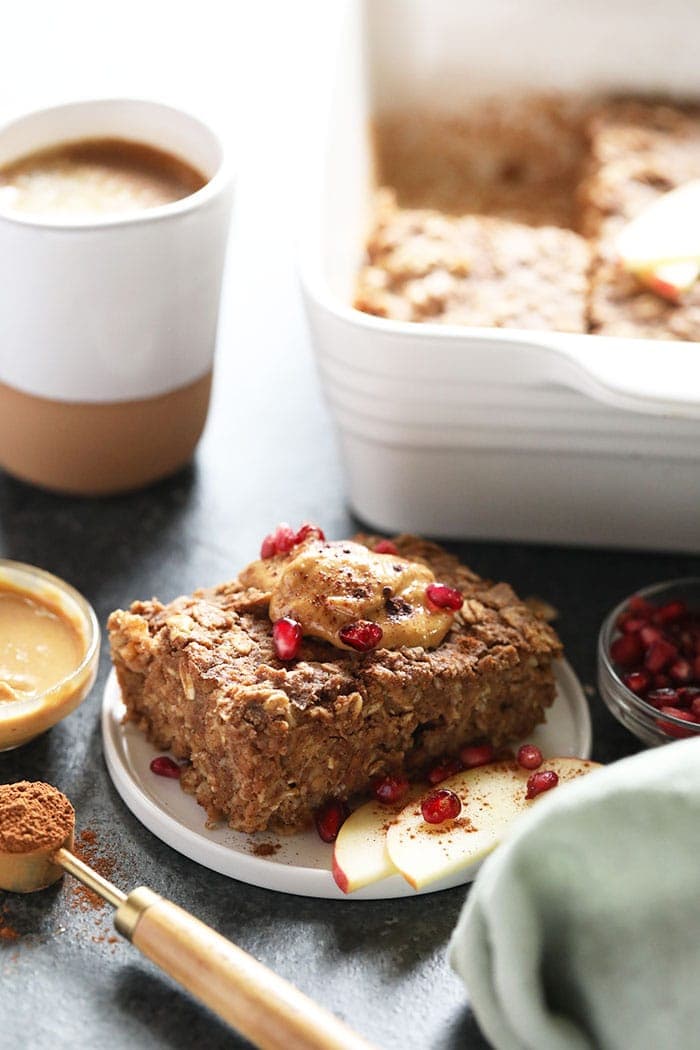 Give your favorite baked oatmeal recipe a fall twist with this amazing Apple Cinnamon Baked Oatmeal. This recipe is made with rolled oats, shredded apples, cinnamon, and a little maple syrup for good measure. Slice of oatmeal bake on a plate.