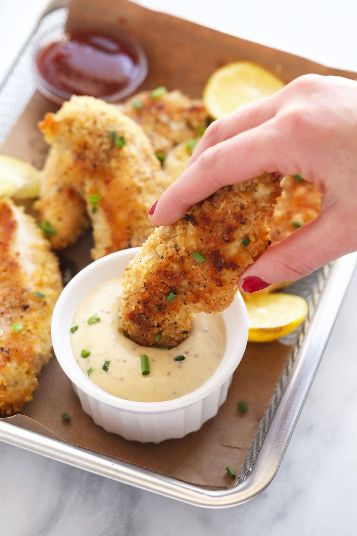 dipping chicken tenders into honey mustard