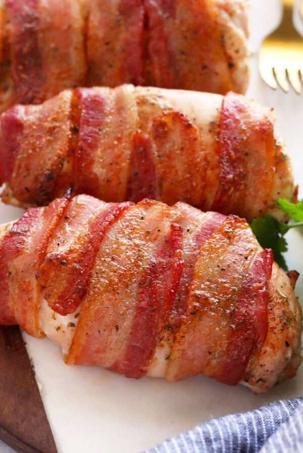 bacon wrapped chicken on cutting board