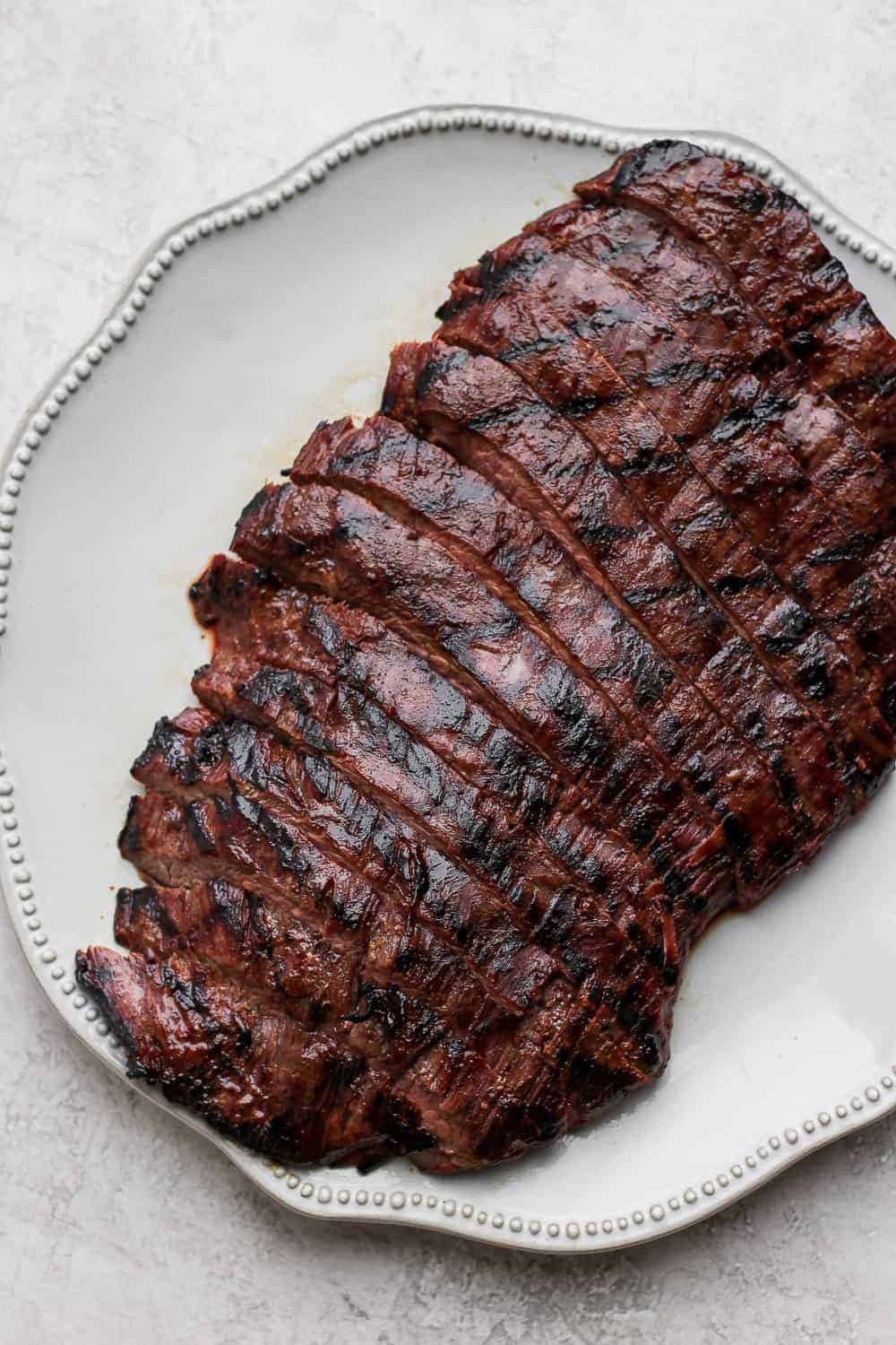 This flank steak marinade is easy to make and packed with 7 flavorful ingredients. Use it to marinate any flank steak. Enjoy! Sliced flank steak on a plate.