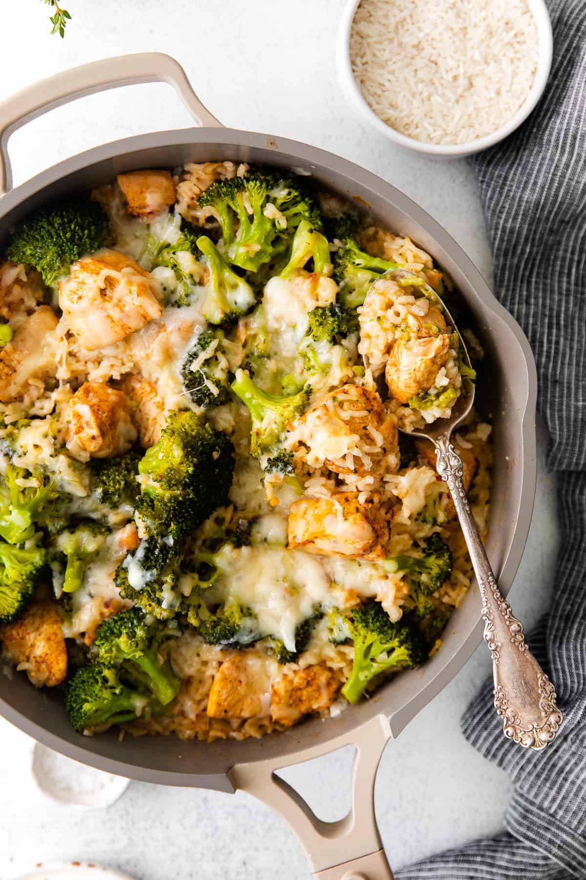 This chicken broccoli and rice casserole recipe features lean chicken breast, rice, broccoli, and a yummy cheese sauce to round it out. chicken caserole in skillet