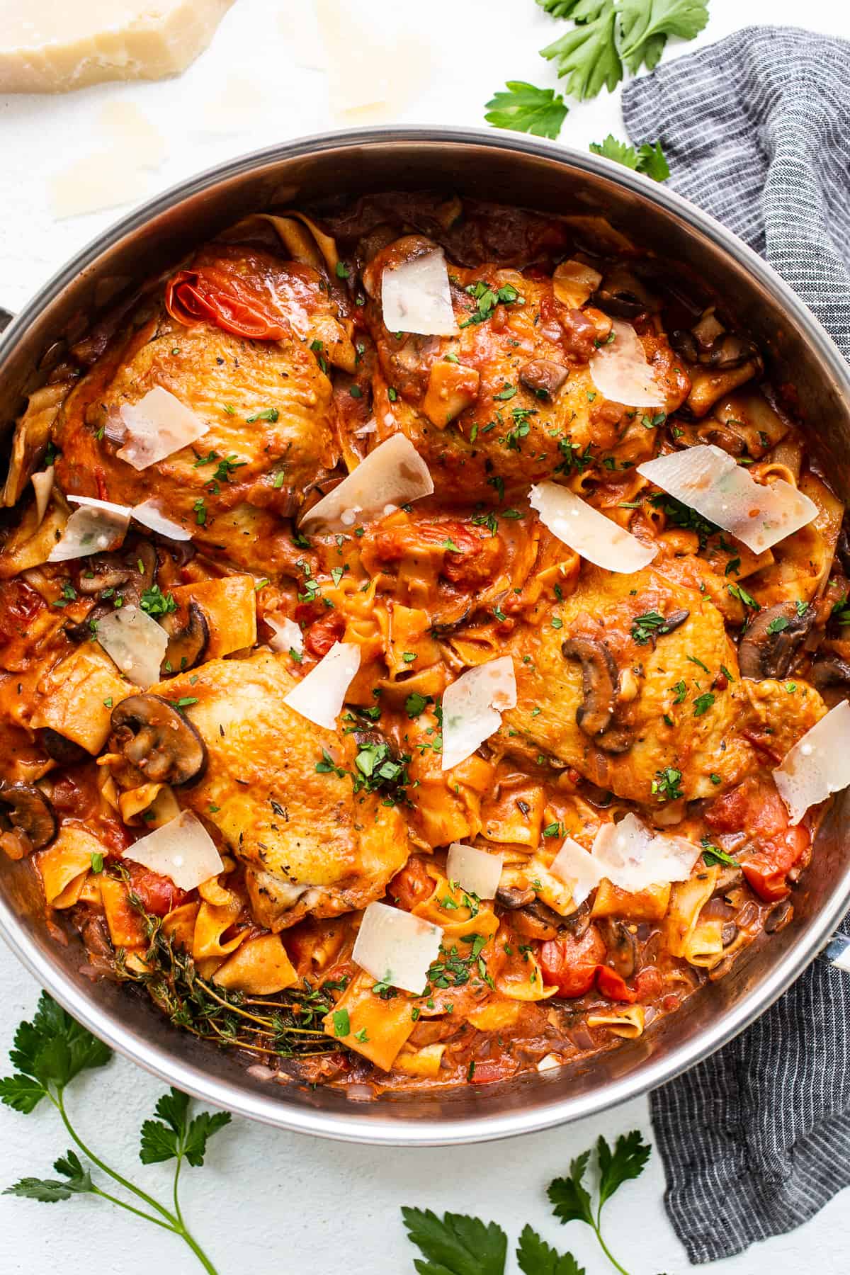 This one-pot pappardelle pasta with chicken thighs makes for the most delicious dinner. The chicken and pappardelle pasta are cooked in a creamy, rich sauce of onions, mushrooms, and tomatoes and topped with shaved parmesan cheese. Pappardelle pasta with chicken thighs in a pot.