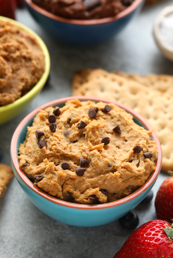 a bowl of edible cookie dough with strawberries and crackers.
