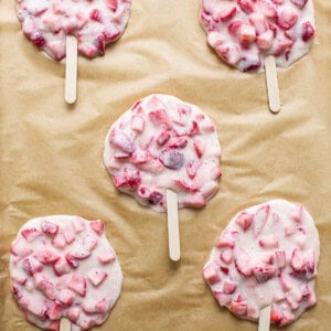 Strawberry popsicles on a baking sheet.