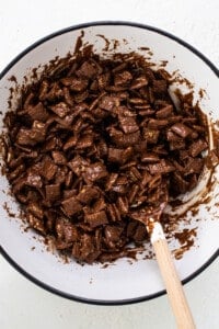A bowl of chocolate granola with a wooden spoon.