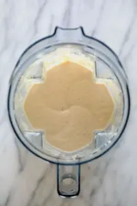 A food processor filled with a mixture of banana protein shake ingredients.