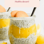 Glass jar of chia seed pudding with lemon layer, topped with two vanilla wafers and a spoon.