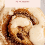 Close-up of a cinnamon roll topped with brown sugar and glaze, surrounded by chocolate chips. Text reads: "High-Protein Cinnamon Rolls, PB + Chocolate.